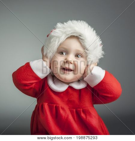 portrait of cute female caucasian child with santa claus clothes