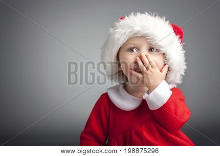 portrait of cute female caucasian child with santa claus clothes