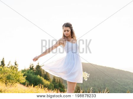 Curly woman happy smiling joyful on field in summer during holidays. Beautiful young cheerful female model.Young woman outdoors.Freedom concept.