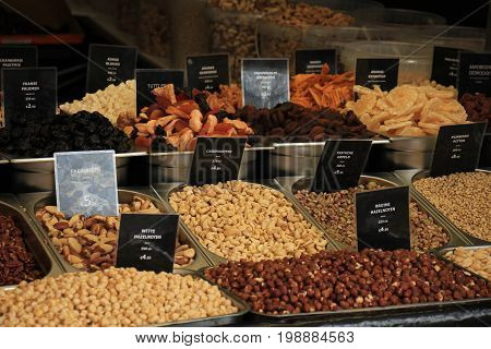 Fresh nuts on a market stall (text on tags: names and prices of various nuts in Dutch white and brown hazel nuts pistacho para and cashew)