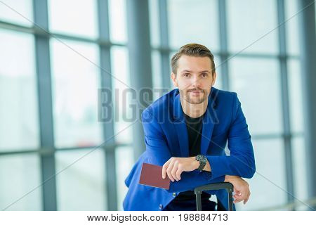 Closeup of man holding passports and boarding pass at airport