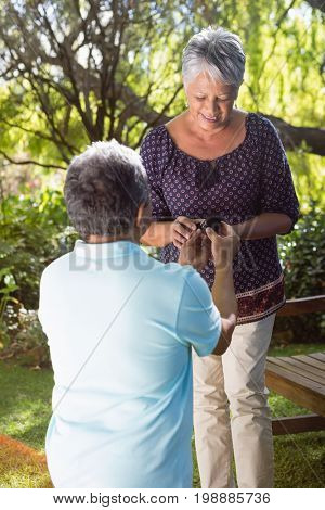 Senior man proposing woman by gifting ring in garden