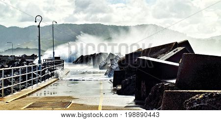 Huge seven meter seas breaking over the Coffs Harbour Marina breakwall during a savage winter sea storm. Photographed at Coffs Harbour New South Wales Australia.