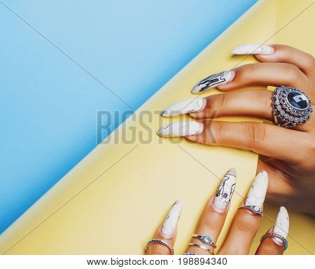 woman hands holding colorful paper copyspace wearing a lot of oriental jewelry rings,  indian girl concept close up
