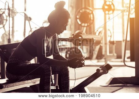 Healthy Woman Relaxing After Exercise And Search Song With Listen Music After The Workout.