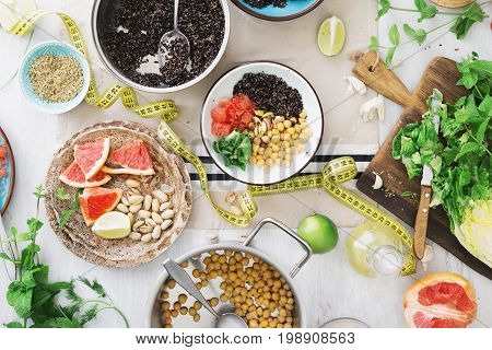Tape measuring with variety healthy food on wooden table. top view. Cooking healthy food concept