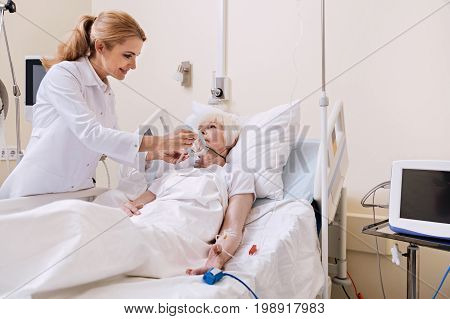 Neat worker. Wonderful experienced neat woman making old lady feeling comfortable and putting on an oxygen mask for ensuring quicker recovery