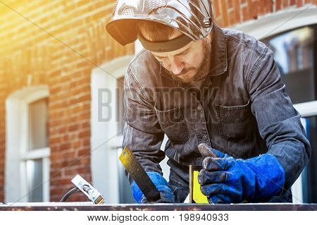 Man Makes A Metal Construction