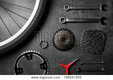 Bicycle parts and repair tools on gray background