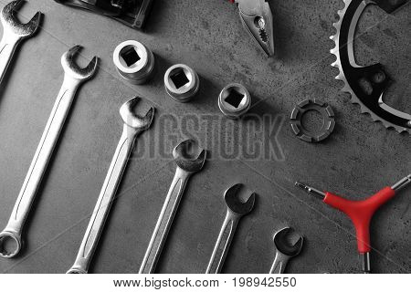 Bicycle parts and repair tools on gray background