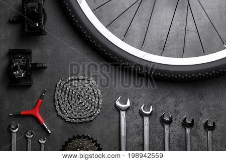 Bicycle parts and repair tools on gray background