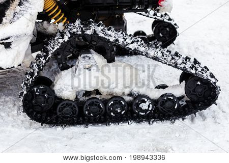 Close up photo of snowmobile caterpillar treads in the snow shallow DOF
