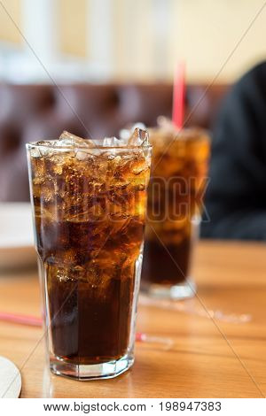 Double soft drink carbonated fresh food soda white dish on wooden table with handsome man sitting brown sofa in pizzeria restaurant