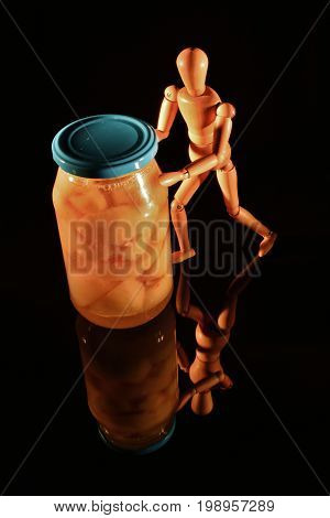 Canned fruit with wooden doll and black background