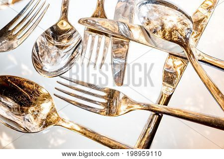 Fork, spoon and knife with reflections and light effects