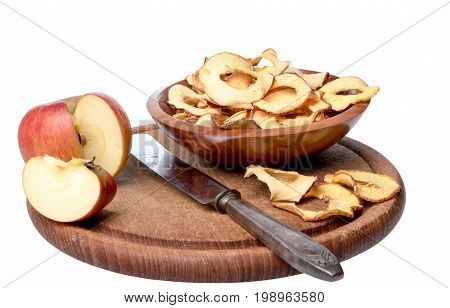 Dried apple rings lie on a board with a freshly cut apple