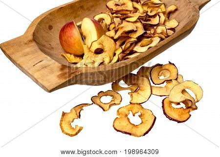 Dried apple rings lie on a board with a freshly cut apple