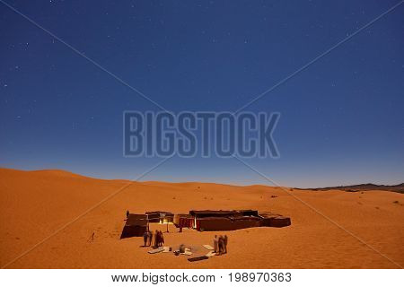 Camp In Sahara Desert In Night With Moon As Star