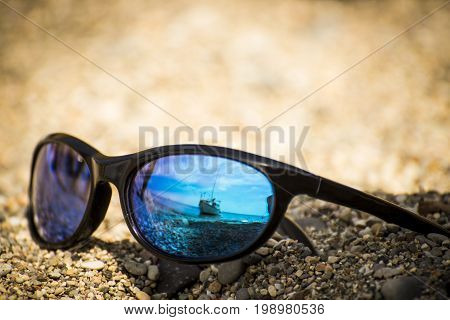 Sunglasses lie in the sand on the beach