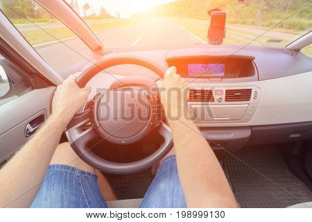 Driving a car - first person view. Hands on steering wheel 