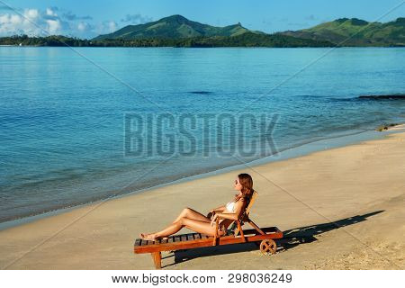 Young Woman Sitting In A Sun Chair On The Beach, Nacula Island, Yasawas, Fiji