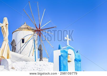 Famous Travel Places. Picturesque View Of Traditional Windmill In Oia Village In Santorini Island In