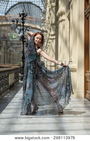 Playful Young Model Demonstrates Fashionable Gauzy Clothing In An Aged Building Under The Daylight