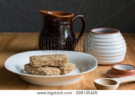 Cereal Bars In Bowl, With Milk And Honey Jar In Background