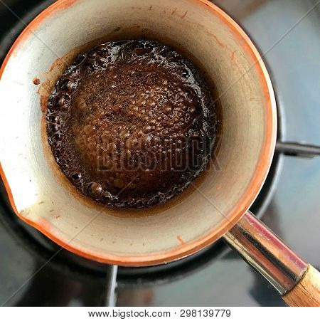 Barista Preparing Hot Tasty Drink From Copper Turk, Boils Water For Coffee On Small Fire In Cezve. C