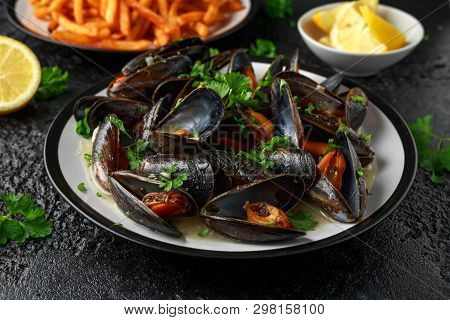 Mussels With White Wine, Garlic, Lemon And Herbs In A Plate, French Fries. Rustick Background. Seafo