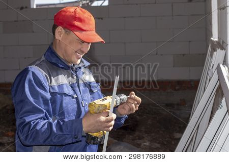 Workers Install Glazing In A House Under Construction, Make Measurements, Drill, Saw Grinder