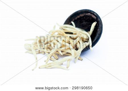 Close Up Of Popular Indian & Asian Ayurvedic Herb Isolated On White In A Clay Bowl I.e. Musli Or Saf