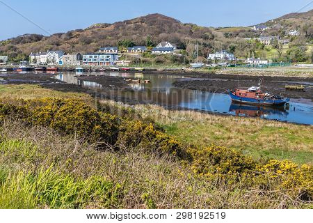 Pier With Buildings And Boat In A Low Tide Clifden Bay