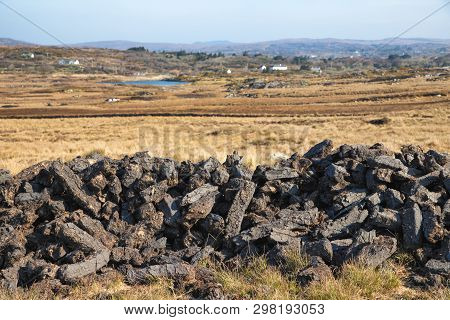 Turf In A Bog With Vegetation And Farm In Background