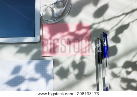 Work Office Space With A Tablet, Notebook, Pens And Headphones Top View, Flat Lay, Copy Space. Pink 