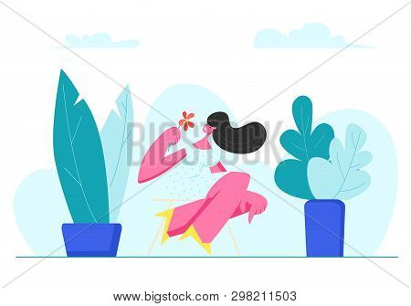 Young Adorable Woman With Flower In Hands Sit On Stool Outdoors Among Green Pants. Summertime Leisur