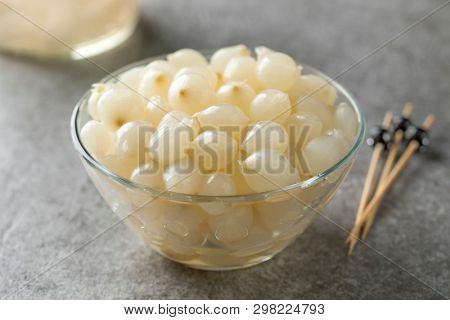Glass bowl with traditional pickled silverskin onions close up