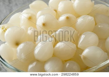 Glass bowl with traditional pickled silverskin onions close up