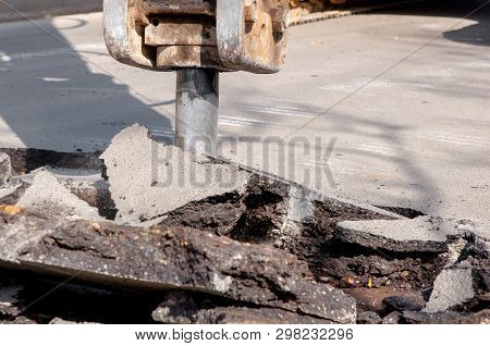 Machine Drills Asphalt. Large Fragments Of Land And Pits Everywhere On The Road. Working Equipment W