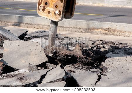 Machine Drills Asphalt. Large Fragments Of Land And Pits Everywhere On The Road. Working Equipment W