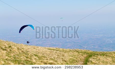 Paraglider On Blue Sky. Borso Del Grappa, Famous Paragliding Site, Italy