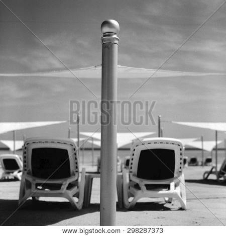 Stylish Lounger In Yellow Sand To Sun Sunbed On Beach In Summer Under Open Sky. Sunbed Intended For 