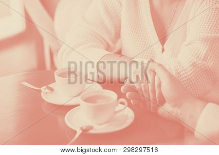 Man And Woman Hold Hands, Close Up Of Couples Arms On Red Wooden Table In Restaurant With Two White 