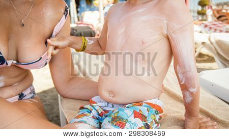 Image Of Young Caring Mother Applying Sunscreen On Her Child To Protect From Harmful Uv Light On Bea