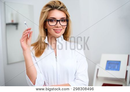 Portrait Of Young Attractive Beautician Doctor With Syringe In Hand. Cosmetologist Holding Medical T