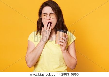 Portrait Of Beautiful Charismatic Young Female Holding Papercup With Coffee, Covering Mouth While Ya