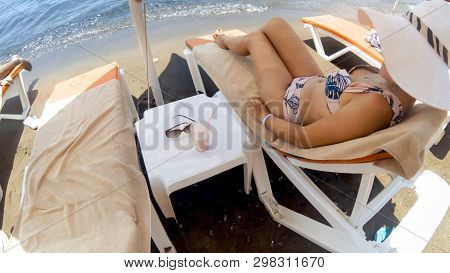 Beeautiful Young Woman Relaxing On The Sunbed By The Sea