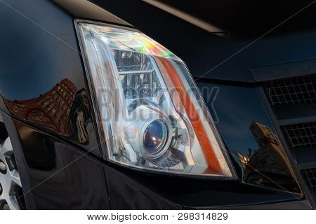 Front Headlamp View Of Black Used Car Stands In The Auto Showroom Sale After Washing And Polish With