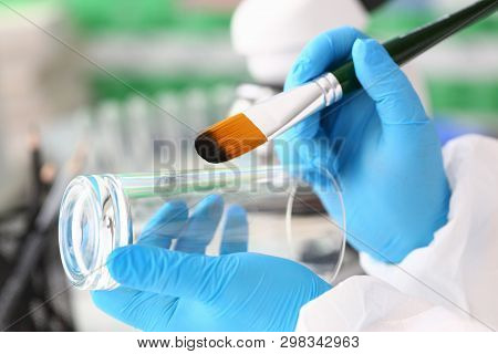 Male Hand In Blu Protective Gloves Hold Brush. Criminal Investigation Concept