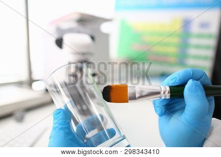 Male Hand In Blu Protective Gloves Hold Brush. Criminal Investigation Concept